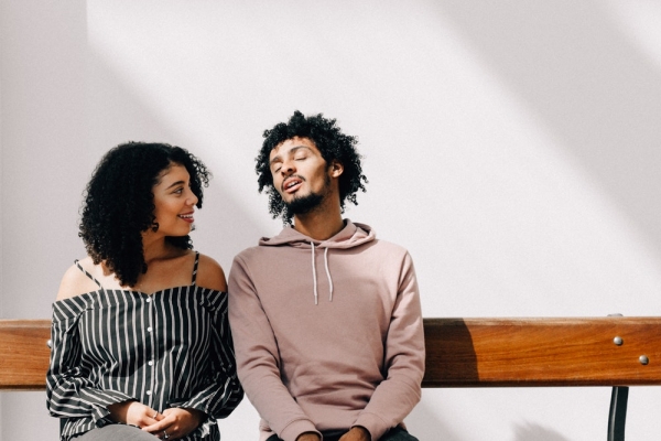 man in pown drawstring pullover hoodie sitting on pown bench beside woman