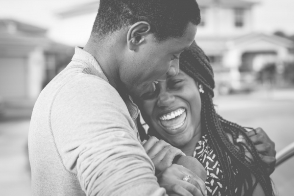 grayscale photography of man hugging woman