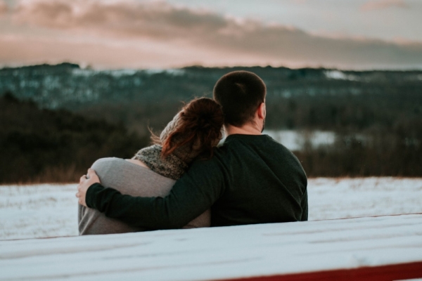 man and woman sitting on bench during daytime